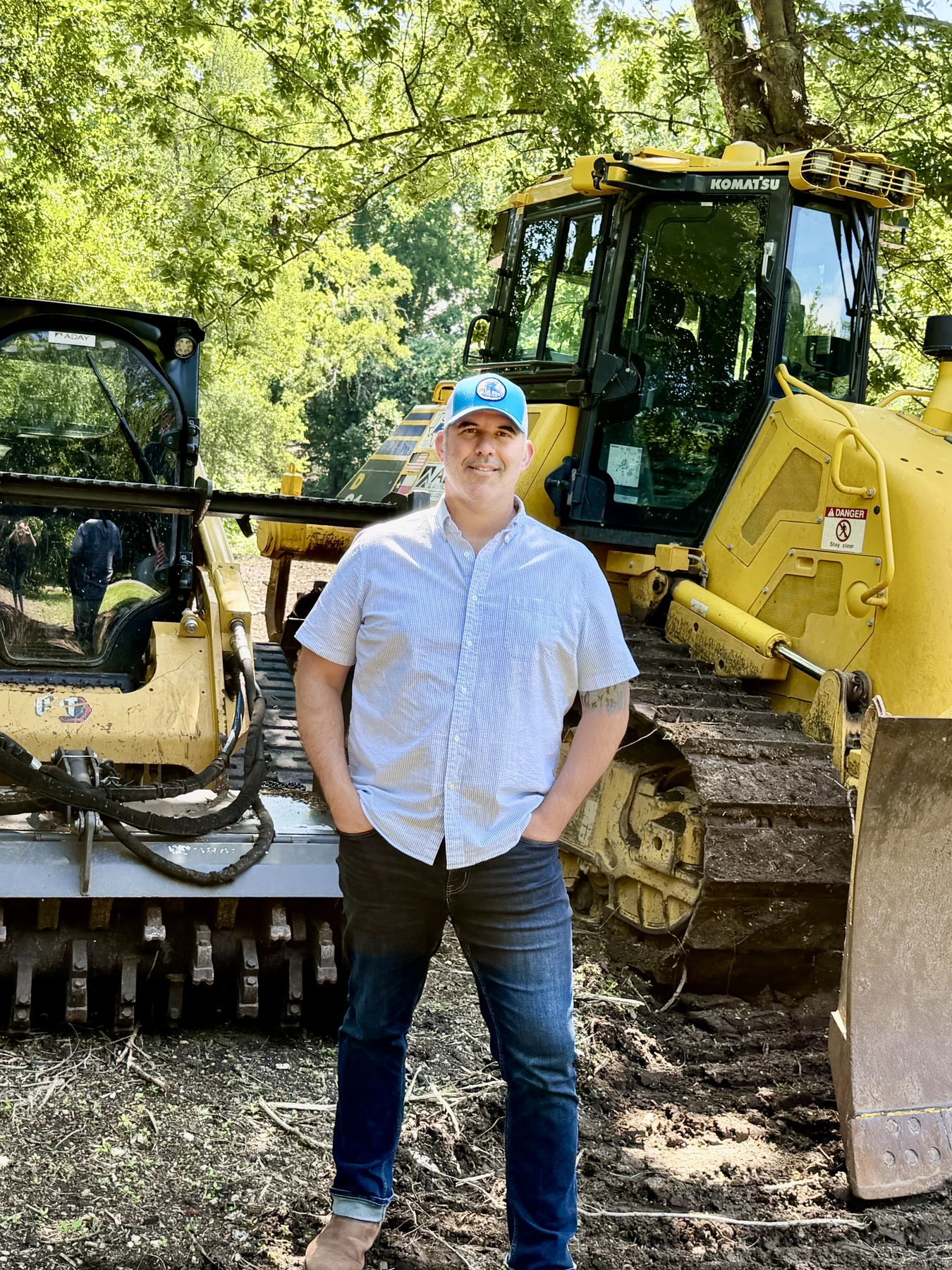 Josh Stockel at a worksite beside yellow excavation equipment